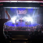 A view of USS playing at the Algonquin Commons Theatre from the balcony level with the audience all up their feet cheering along